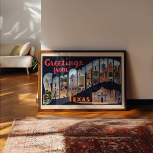 May include: A framed vintage postcard print with the words "Greetings from SAN ANTONIO TEXAS" in a stylized font. The print features illustrations of San Antonio landmarks and is set against a dark blue background.