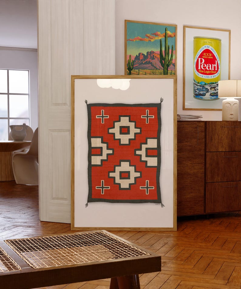 May include: A framed print of a red, white, and black geometric pattern rug. The rug has a traditional Native American design with crosses and squares.