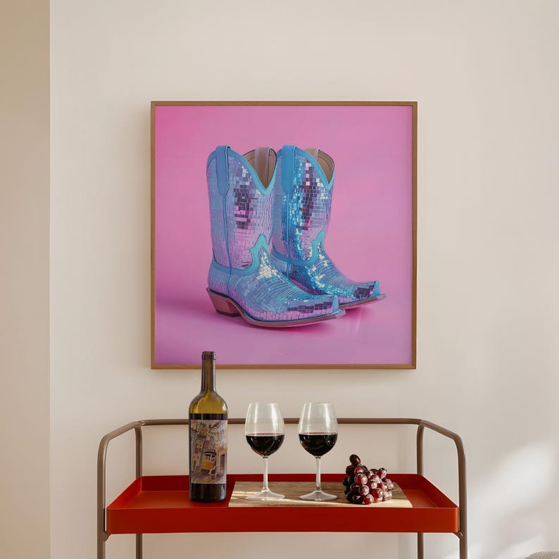 May include: A framed print of a pair of blue sequined cowboy boots on a pink background. A bottle of wine, two wine glasses, and a bowl of grapes are on a red bar cart.