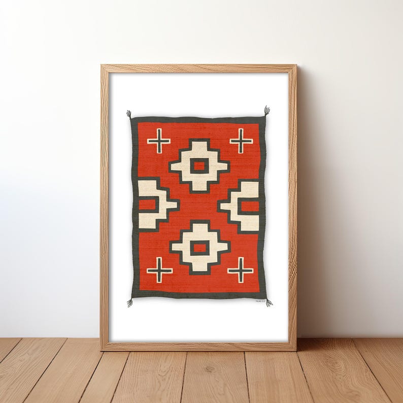 May include: A framed print of a Native American rug with a geometric pattern in red, white, and black. The rug is framed in a natural wood frame.