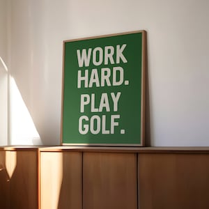 May include: A green framed poster with white text that reads "WORK HARD. PLAY GOLF."
