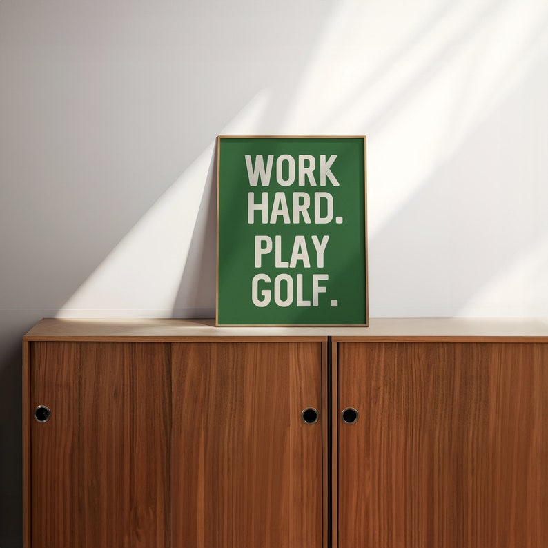 May include: A green framed poster with white text that reads "WORK HARD. PLAY GOLF."