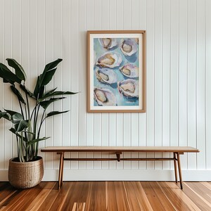 May include: A framed painting of oysters on a blue background. The painting is hanging on a white wall above a wooden bench.