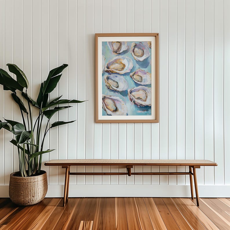 May include: A framed painting of oysters on a blue background. The painting is hanging on a white wall above a wooden bench.