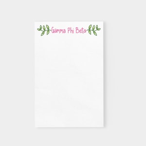 May include: White notepad with a pink "Gamma Phi Beta" text and green leafy vines at the top.