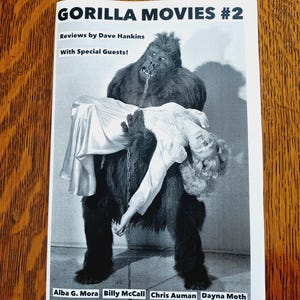 May include: A black and white zine titled GORILLA MOVIES #2, featuring a graphic of a gorilla holding a person in a dress. The text reads Reviews by Dave Hankins, With Special Guests!, and lists names including Alba G. Mora and Billy McCall.