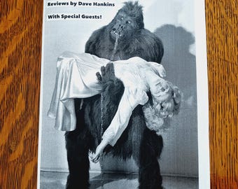 May include: A black and white zine titled GORILLA MOVIES #2, featuring a graphic of a gorilla holding a person in a dress. The text reads Reviews by Dave Hankins, With Special Guests!, and lists names including Alba G. Mora and Billy McCall.