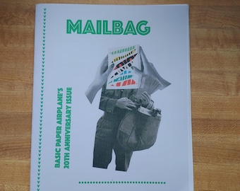 May include: A white magazine cover with the word "MAILBAG" in green block letters. The cover features a black and white illustration of a person holding a paper airplane. The text "BASIC PAPER AIRPLANE'S 20TH ANNIVERSARY ISSUE" is printed vertically on the left side.