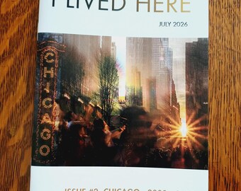 May include: A softcover book titled I LIVED HERE, dated July 2026. The cover features a photograph of the Chicago theater sign at sunset with city buildings. The bottom text reads ISSUE #2 CHICAGO 2000 - 2010 and AUTHOR: BILLY MCCALL.