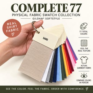 May include: A physical fabric swatch collection titled COMPLETE 77 GILDAN SOFTSTYLE featuring 77 total colors on a metal ring. The swatches are rectangular pieces of actual garment fabric in various shades, with the top swatch labeled SAND.