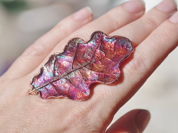 A real oak leaf electroformed in copper and given a rainbow patina — you're literally wearing autumn preserved in metal.