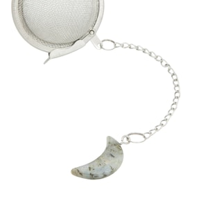 May include: A silver tea infuser with a mesh ball and a chain attached to a crescent moon-shaped labradorite stone.