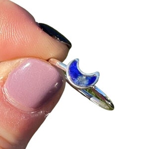 May include: A silver ring with a crescent moon shaped lapis lazuli stone.