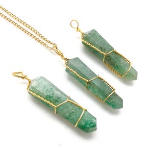 Puede incluir: Tres colgantes de cristal de aventurina verde con puntas hexagonales, cada uno envuelto en un hilo fino de color dorado. Un colgante est&aacute; unido a una cadena de metal dorado, mientras que los otros dos tienen peque&ntilde;as anillas de alambre.