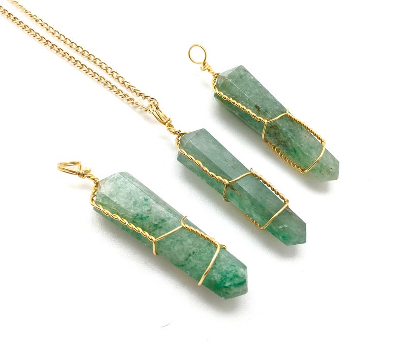 Puede incluir: Tres colgantes de cristal de aventurina verde con puntas hexagonales, cada uno envuelto en un hilo fino de color dorado. Un colgante est&aacute; unido a una cadena de metal dorado, mientras que los otros dos tienen peque&ntilde;as anillas de alambre.