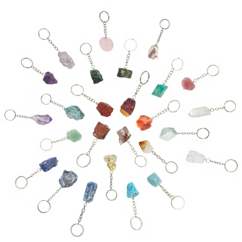 K&ouml;nnte beinhalten: Eine Sammlung von 20 verschiedenen Kristall-Schl&uuml;sselanh&auml;ngern. Jeder Schl&uuml;sselanh&auml;nger zeigt einen einzigartigen Kristall, darunter Amethyst, Rosenquarz, klarer Quarz und vieles mehr. Die Schl&uuml;sselanh&auml;nger sind alle silberfarben und haben einen runden Ring oben.