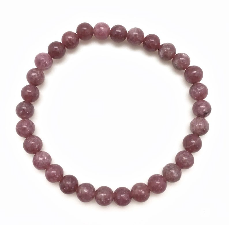 Puede incluir: Un brazalete de piedras preciosas rosa y blancas con cuentas redondas.