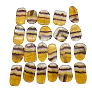 Può includere: Una collezione di 20 pietre di fluorite levigate. Le pietre sono un mix di giallo, bianco e viola. Sono tutte lisce e lucidate.