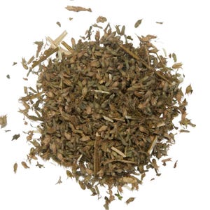 May include: A close-up of a pile of dried herbs and seeds, displaying a mix of brown, green, and tan colours. The image highlights the texture and variety of the plant matter, with small seed pods and stems visible against a plain white background.