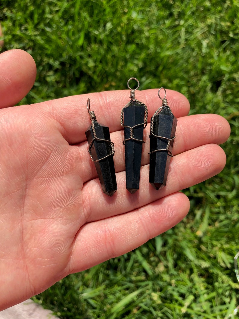 Pode incluir: Tr&ecirc;s pingentes de cristal de obsidiana preta envoltos em fio de prata. Cada pingente tem um la&ccedil;o na parte superior para prender a um colar ou pulseira.