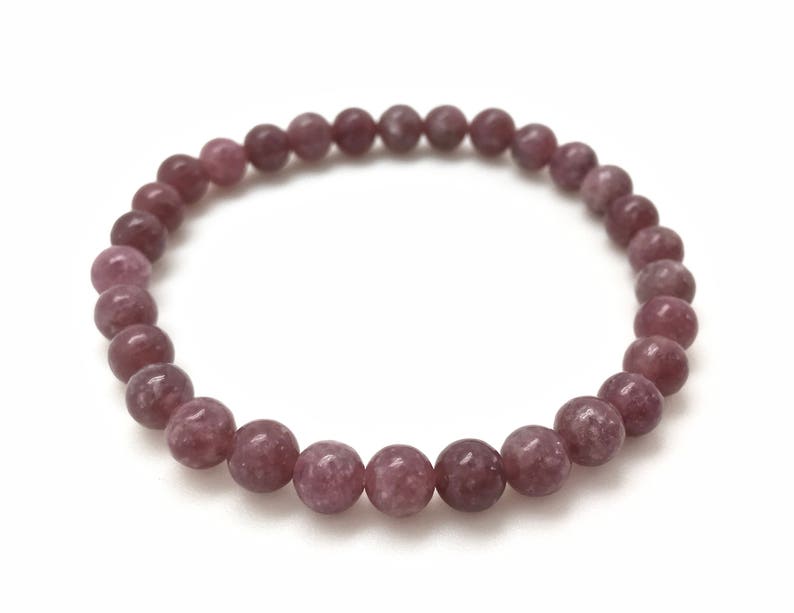 Puede incluir: Un brazalete de piedras preciosas rosa y gris con cuentas redondas.