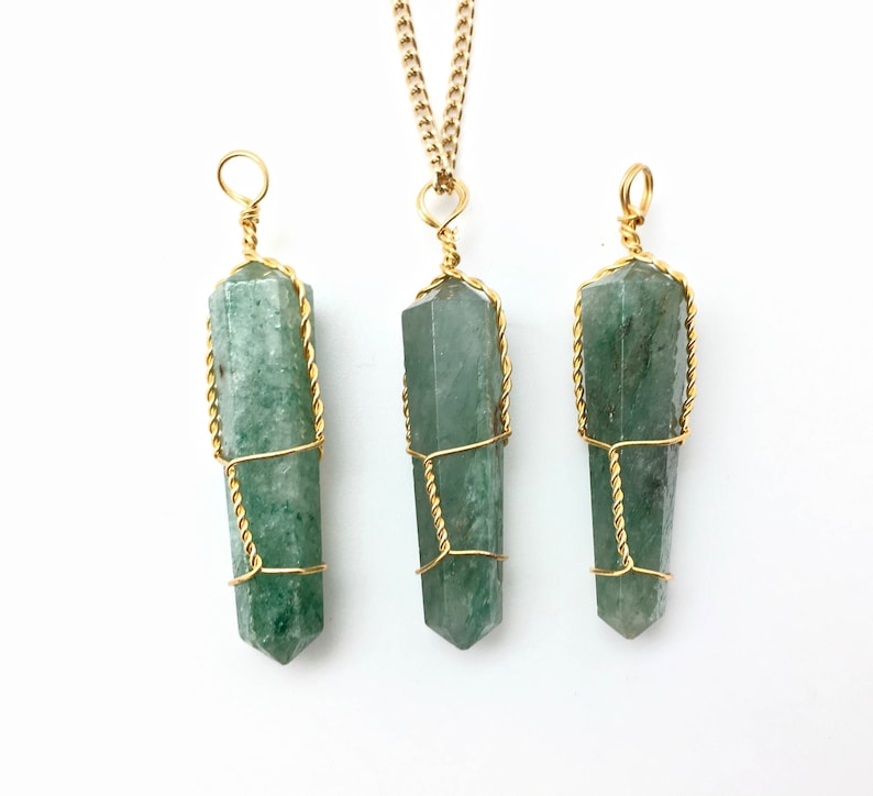 Puede incluir: Tres colgantes de piedra verde, de forma hexagonal y corte en punta, envueltos en alambre de color dorado. El colgante central est&aacute; unido a una cadena dorada, mientras que los dos laterales tienen un lazo de alambre en la parte superior.