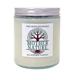 May include: A white candle jar with a silver lid. The label says "New Moon Beginnings" and features a green tree with brown roots and the text "Mother Nature All Natural Candles".