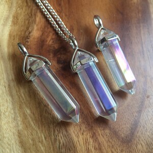 May include: Three iridescent clear quartz crystal pendants with silver settings. The crystals are faceted and have a rainbow sheen.