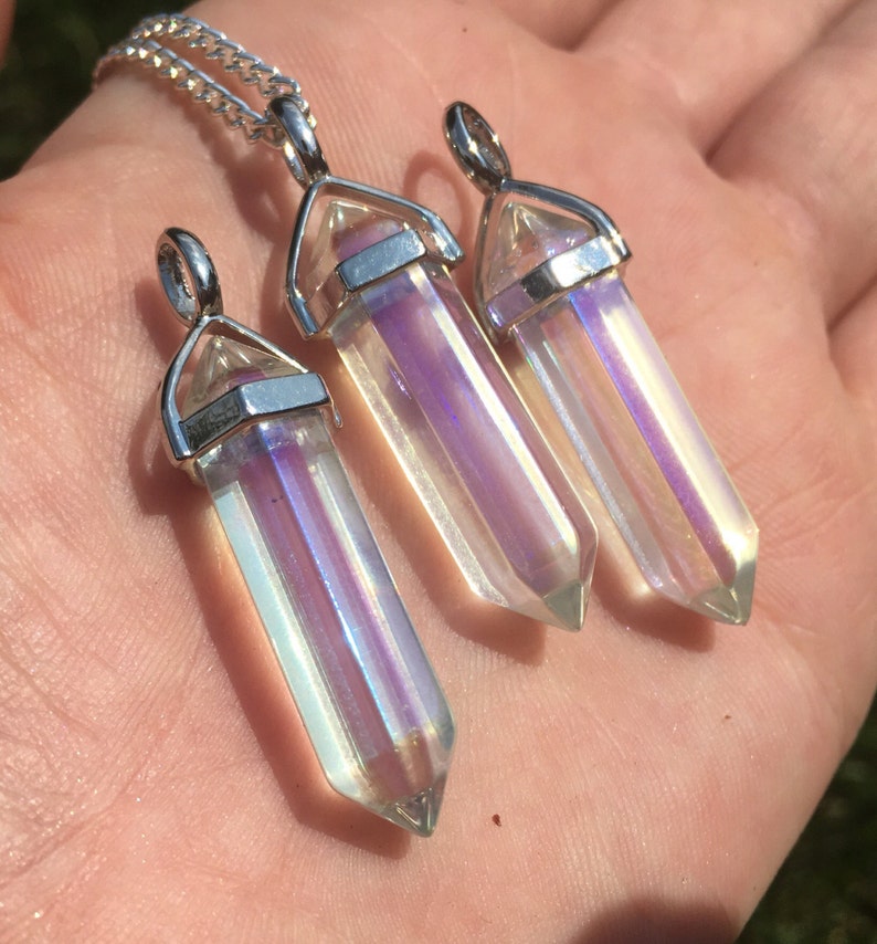 May include: Three iridescent crystal point pendants on silver chains. The crystals are clear with a rainbow sheen.