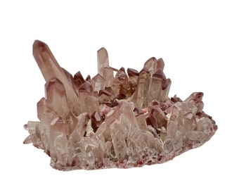 May include: A cluster of pink and red quartz crystals with a rough, natural texture. The crystals are arranged in a random, organic pattern, creating a unique and eye-catching display.