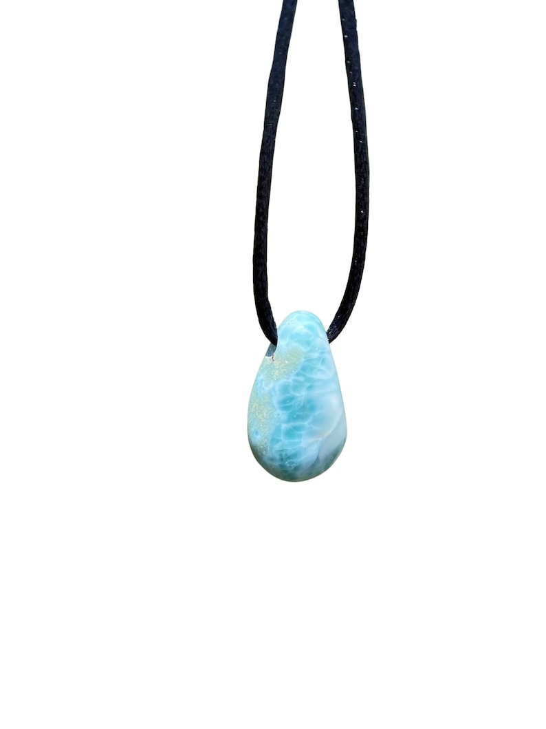 May include: A teardrop-shaped blue and green gemstone pendant on a black cord necklace.