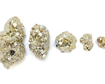 May include: Five pyrite crystals of varying sizes, ranging from small to large, on a white background. The crystals are a metallic gold color and have a rough, textured surface.