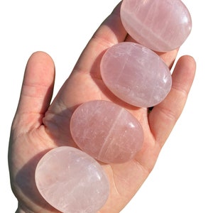 Pu&ograve; includere: Quattro pietre di quarzo rosa lisce, di forma ovale, in diverse tonalit&agrave; di rosa. Le pietre sono lucidate e hanno un aspetto traslucido.