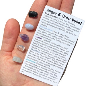 May include: A set of seven small crystals for anger and stress relief. The crystals are black tourmaline, blue lace agate, amethyst, and clear quartz. The card describes the properties of each crystal.