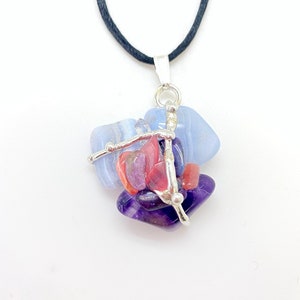 May include: A silver necklace with a pendant made of blue, purple, and pink stones. The stones are held together by silver wire.
