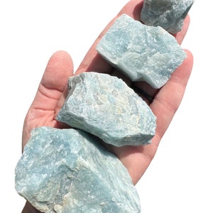 a person holding three rocks in their hand