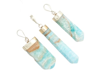 May include: Three silver pendant charms with blue and brown aquamarine stones. The stones are faceted and have a natural, organic look.