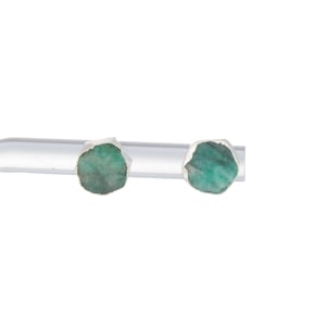 Puede incluir: Un par de pendientes de plata con piedras preciosas de esmeralda verde.