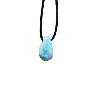 May include: A blue and green gemstone pendant on a black cord necklace.