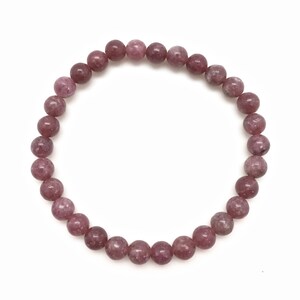 Puede incluir: Un brazalete de piedra de Lepidolita rosa y blanca con cuentas redondas.