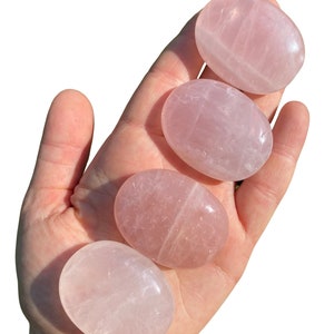 Pu&ograve; includere: Quattro pietre di quarzo rosa lisce, di forma ovale, di diverse dimensioni. Le pietre sono rosa pallido e traslucide, con striature visibili.