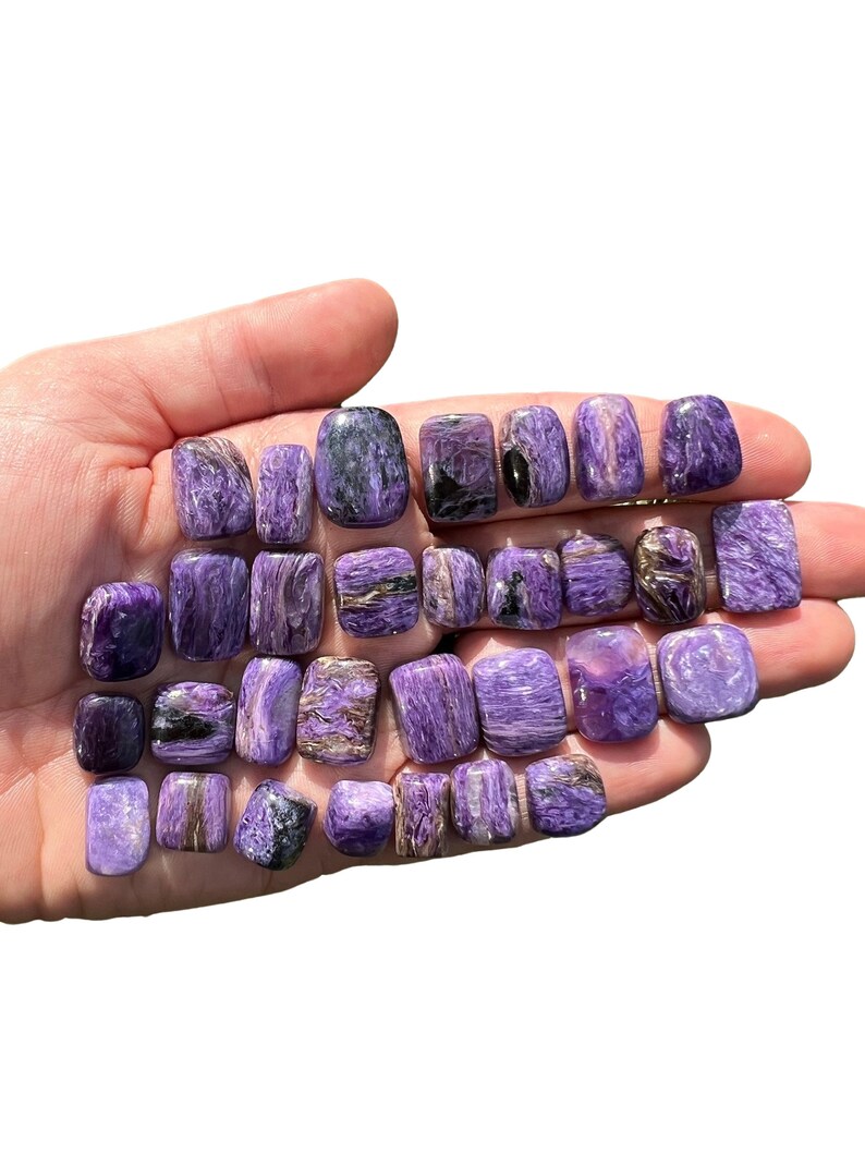 May include: A collection of 20 tumbled stones in shades of purple and silver. The stones are smooth and polished, with a variety of patterns and textures.