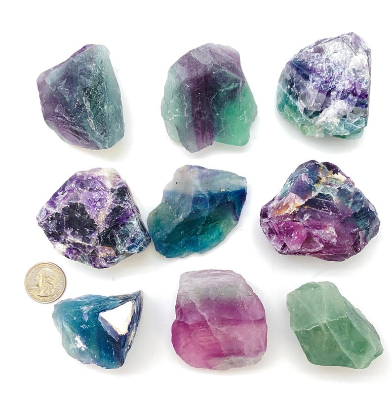 Puede incluir: Nueve cristales de fluorita en varios tonos de verde, morado y azul. Los cristales son &aacute;speros y tienen bordes naturales.