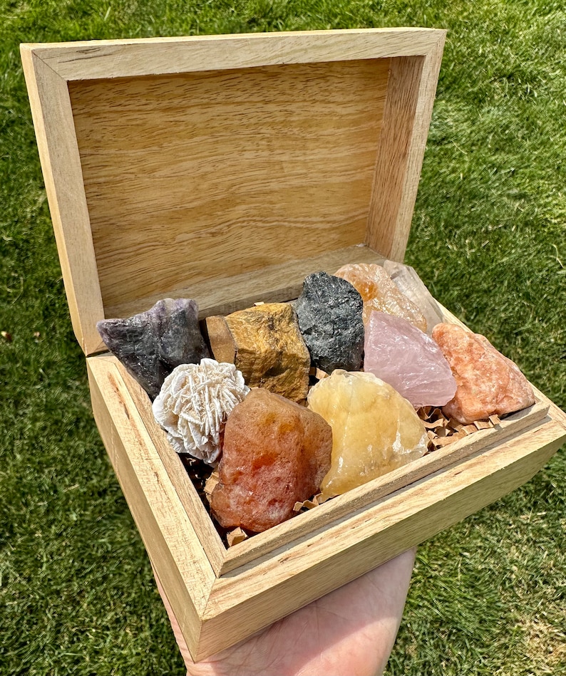 May include: A wooden box filled with a variety of colorful crystals, including rose quartz, amethyst, tiger's eye, and selenite.