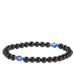 May include: Black beaded bracelet with two blue and white evil eye beads. The bracelet is made of small, round, black beads strung together on an elastic cord. The evil eye beads are a bright blue with a white iris and black pupil.
