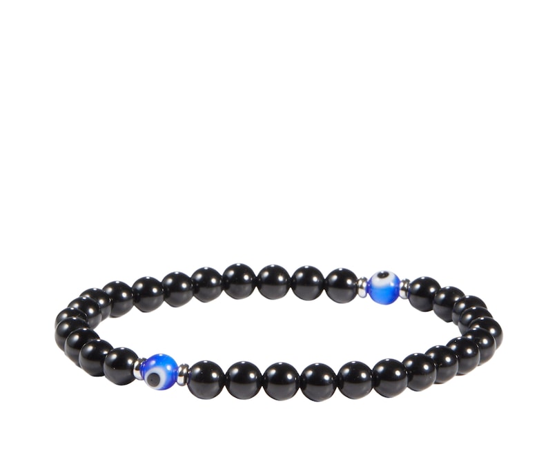 May include: Black beaded bracelet with two blue and white evil eye beads. The bracelet is made of small, round, black beads strung together on an elastic cord. The evil eye beads are a bright blue with a white iris and black pupil.