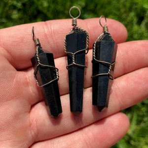 Pode incluir: Tr&ecirc;s pingentes de ponta de cristal de obsidiana preta envoltos em fio de prata. Cada pingente tem um la&ccedil;o na parte superior para prender a um colar ou pulseira.