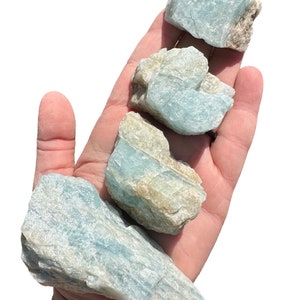 a hand holding three pieces of rock in it's palm