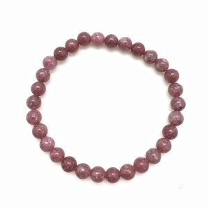 Puede incluir: Un brazalete de piedras preciosas rosa y blancas con cuentas redondas.
