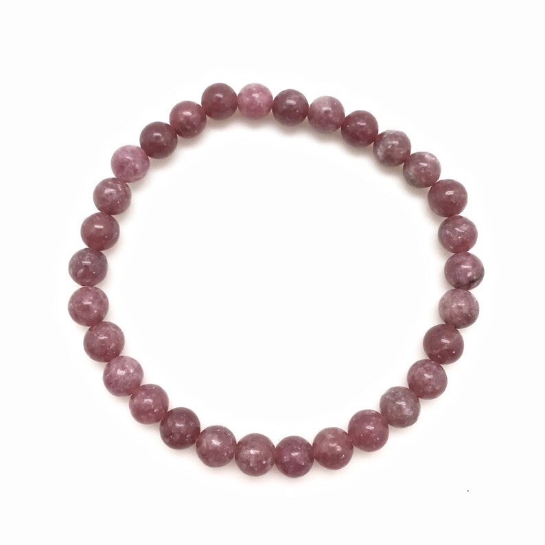 Puede incluir: Un brazalete de piedras preciosas rosa y blancas con cuentas redondas.